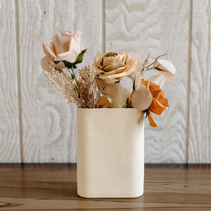 Rust, tan, and taupe flowers and textures arranged in a ceramic vase for a bohemian fall wedding